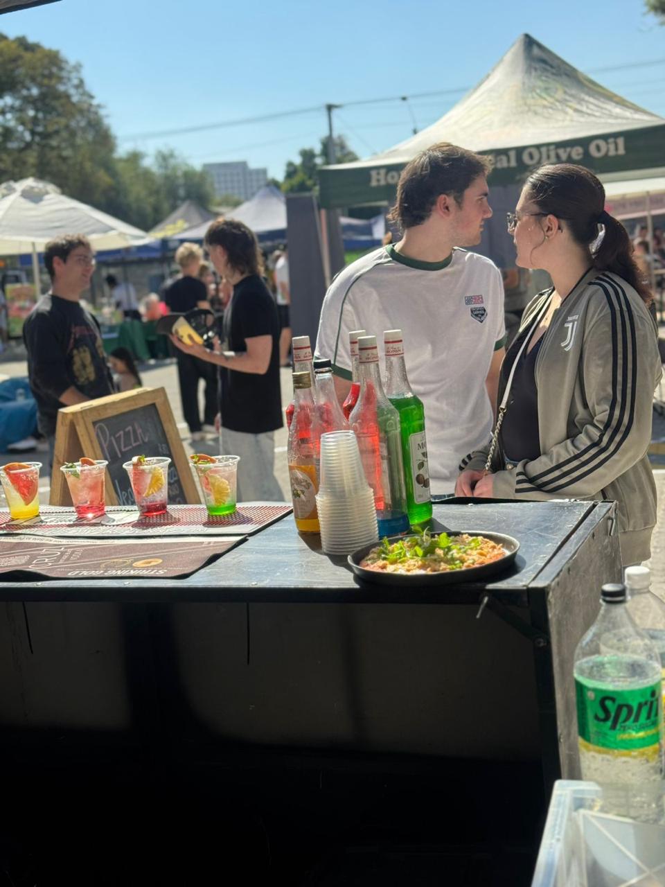 A lively festival atmosphere with music and people enjoying drinks and food.