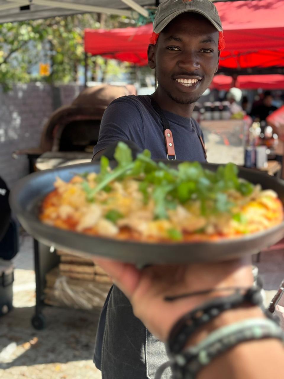 A vibrant outdoor market scene with food stalls and people enjoying the atmosphere.