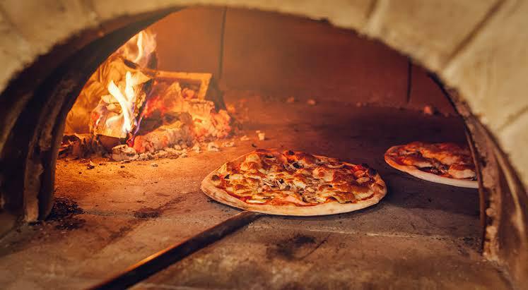 A delicious, rustic wood-fired pizza with fresh toppings, just out of the oven.